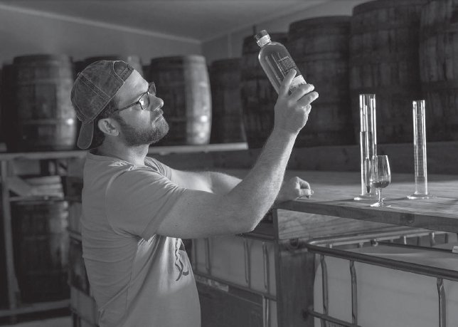 Trevor Bruns inspecting a bottle of rum